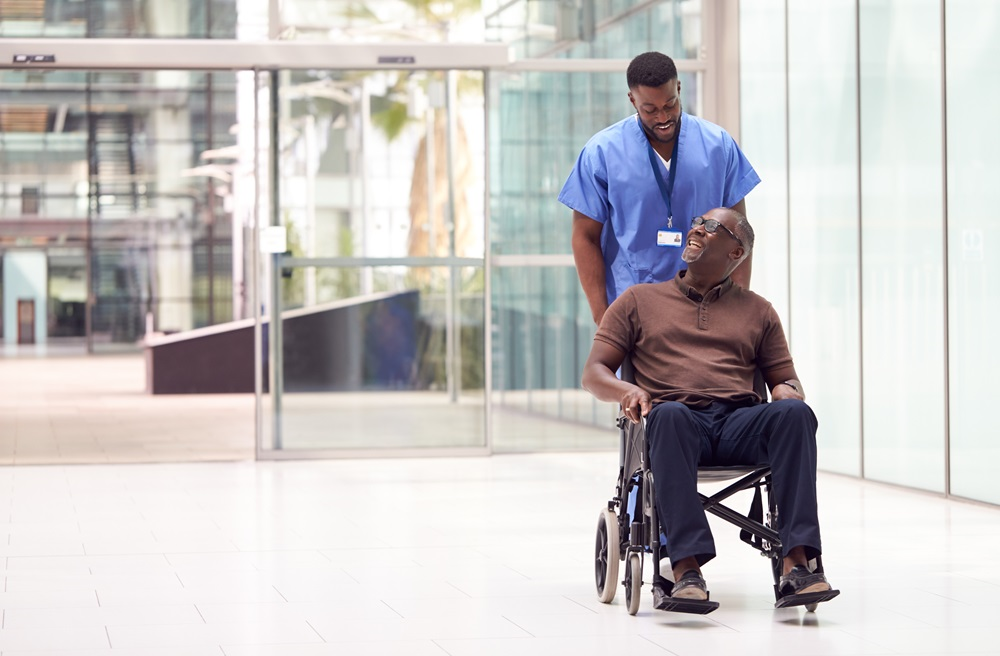 A nurse transports a patient through the hospital by way of a wheelchair